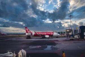 red and white passenger plane on airport during daytime